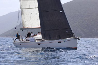 Bodrum, Hindi. 12 Mart 2023: Yelkenliler Ege Denizi 'nin mavi sularında, ünlü tatil beldesi Bodrum' un kıyılarında rüzgarlı havada yelken açıyorlar..