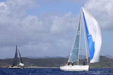 Bodrum, Hindi. 12 Mart 2023: Yelkenliler Ege Denizi 'nin mavi sularında, ünlü tatil beldesi Bodrum' un kıyılarında rüzgarlı havada yelken açıyorlar..