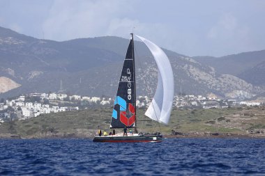 Bodrum, Hindi. 12 Mart 2023: Yelkenliler Ege Denizi 'nin mavi sularında, ünlü tatil beldesi Bodrum' un kıyılarında rüzgarlı havada yelken açıyorlar..