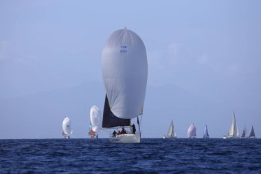 Bodrum, Hindi. 12 Mart 2023: Yelkenliler Ege Denizi 'nin mavi sularında, ünlü tatil beldesi Bodrum' un kıyılarında rüzgarlı havada yelken açıyorlar..