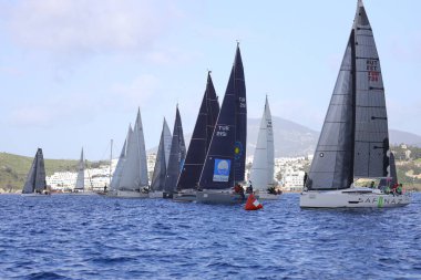 Bodrum, Hindi. 12 Mart 2023: Yelkenliler Ege Denizi 'nin mavi sularında, ünlü tatil beldesi Bodrum' un kıyılarında rüzgarlı havada yelken açıyorlar..