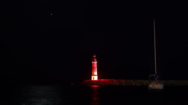 Venüs önce batar, sonra ay, kırmızı deniz fenerinin üzerinde. Yeni ay fenerin merkezinden geçer. Denizdeki bir yelkenlinin zaman çizelgesi.