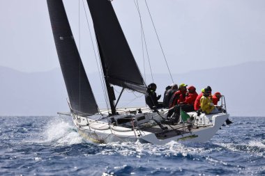 Bodrum, Hindi. 12 Mart 2023: Yelkenliler Ege Denizi 'nin mavi sularında, ünlü tatil beldesi Bodrum' un kıyılarında rüzgarlı havada yelken açıyorlar..