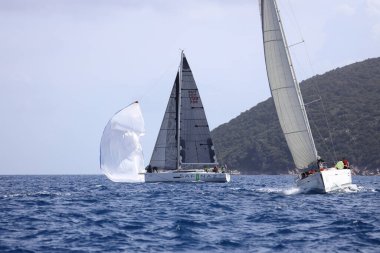 Bodrum, Hindi. 12 Mart 2023: Yelkenliler Ege Denizi 'nin mavi sularında, ünlü tatil beldesi Bodrum' un kıyılarında rüzgarlı havada yelken açıyorlar..
