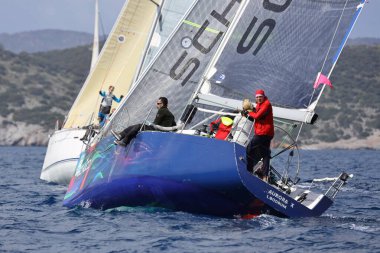 Bodrum, Hindi. 12 Mart 2023: Yelkenliler Ege Denizi 'nin mavi sularında, ünlü tatil beldesi Bodrum' un kıyılarında rüzgarlı havada yelken açıyorlar..