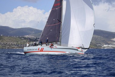 Bodrum, Hindi. 12 Mart 2023: Yelkenliler Ege Denizi 'nin mavi sularında, ünlü tatil beldesi Bodrum' un kıyılarında rüzgarlı havada yelken açıyorlar..