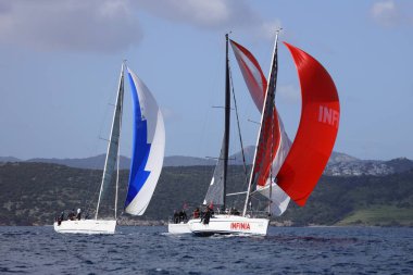 Bodrum, Hindi. 12 Mart 2023: Yelkenliler Ege Denizi 'nin mavi sularında, ünlü tatil beldesi Bodrum' un kıyılarında rüzgarlı havada yelken açıyorlar..