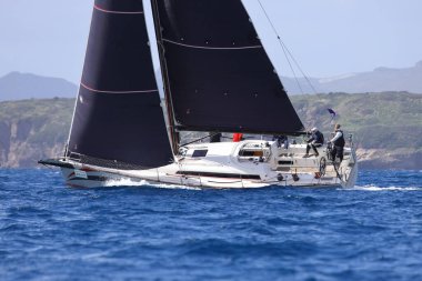 Bodrum, Hindi. 12 Mart 2023: Yelkenliler Ege Denizi 'nin mavi sularında, ünlü tatil beldesi Bodrum' un kıyılarında rüzgarlı havada yelken açıyorlar..