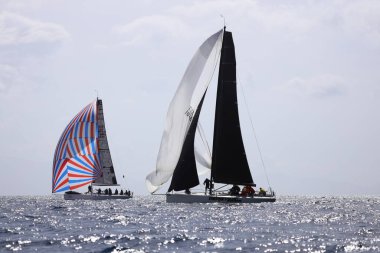 Bodrum, Hindi. 12 Mart 2023: Yelkenliler Ege Denizi 'nin mavi sularında, ünlü tatil beldesi Bodrum' un kıyılarında rüzgarlı havada yelken açıyorlar..