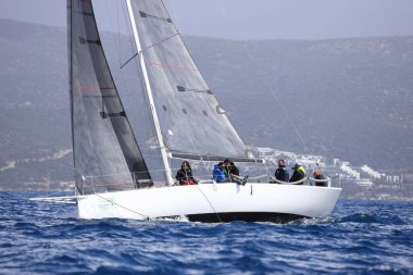 Bodrum, Hindi. 12 Mart 2023: Yelkenliler Ege Denizi 'nin mavi sularında, ünlü tatil beldesi Bodrum' un kıyılarında rüzgarlı havada yelken açıyorlar..