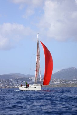 Bodrum, Hindi. 12 Mart 2023: Yelkenliler Ege Denizi 'nin mavi sularında, ünlü tatil beldesi Bodrum' un kıyılarında rüzgarlı havada yelken açıyorlar..