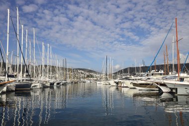 Bodrum, Hindi. 12 Mart 2023: Bodrum, Marina 'nın sakin sularına yansıyan yelkenliler ve yatlar insanların teknelerini yanaştırıp denize açılabilecekleri yerler