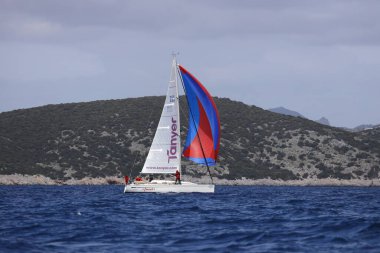 Bodrum, Hindi. 01 Nisan 2023: Ege Denizi 'nin mavi sularında, ünlü tatil beldesi Bodrum' un kıyılarında, rüzgarlı havada yelkenliler yelken açıyor.
