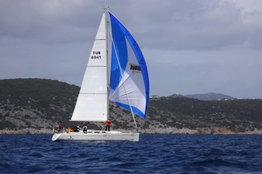 Bodrum, Hindi. 01 Nisan 2023: Ege Denizi 'nin mavi sularında, ünlü tatil beldesi Bodrum' un kıyılarında, rüzgarlı havada yelkenliler yelken açıyor.