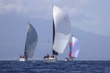 Bodrum, Hindi. 01 Nisan 2023: Ege Denizi 'nin mavi sularında, ünlü tatil beldesi Bodrum' un kıyılarında, rüzgarlı havada yelkenliler yelken açıyor.