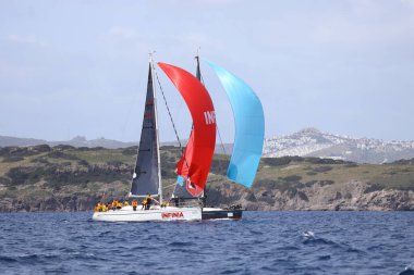 Bodrum, Hindi. 01 Nisan 2023: Ege Denizi 'nin mavi sularında, ünlü tatil beldesi Bodrum' un kıyılarında, rüzgarlı havada yelkenliler yelken açıyor.