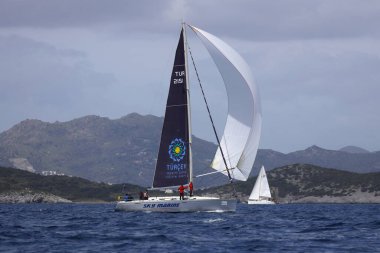 Bodrum, Hindi. 01 Nisan 2023: Ege Denizi 'nin mavi sularında, ünlü tatil beldesi Bodrum' un kıyılarında, rüzgarlı havada yelkenliler yelken açıyor.