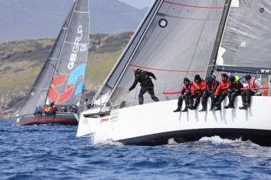 Bodrum, Hindi. 01 Nisan 2023: Ege Denizi 'nin mavi sularında, ünlü tatil beldesi Bodrum' un kıyılarında, rüzgarlı havada yelkenliler yelken açıyor.