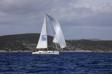 Bodrum, Hindi. 01 Nisan 2023: Ege Denizi 'nin mavi sularında, ünlü tatil beldesi Bodrum' un kıyılarında, rüzgarlı havada yelkenliler yelken açıyor.