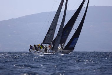 Bodrum, Hindi. 01 Nisan 2023: Ege Denizi 'nin mavi sularında, ünlü tatil beldesi Bodrum' un kıyılarında, rüzgarlı havada yelkenliler yelken açıyor.