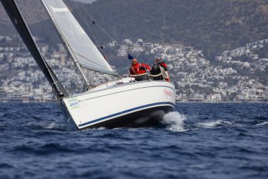 Bodrum, Hindi. 01 Nisan 2023: Ege Denizi 'nin mavi sularında, ünlü tatil beldesi Bodrum' un kıyılarında, rüzgarlı havada yelkenliler yelken açıyor.