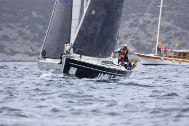 Bodrum, Hindi. 01 Nisan 2023: Ege Denizi 'nin mavi sularında, ünlü tatil beldesi Bodrum' un kıyılarında, rüzgarlı havada yelkenliler yelken açıyor.