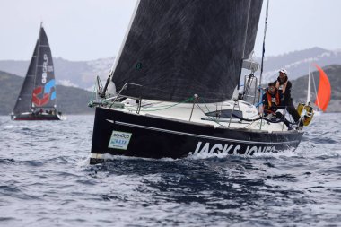 Bodrum, Hindi. 01 Nisan 2023: Ege Denizi 'nin mavi sularında, ünlü tatil beldesi Bodrum' un kıyılarında, rüzgarlı havada yelkenliler yelken açıyor.