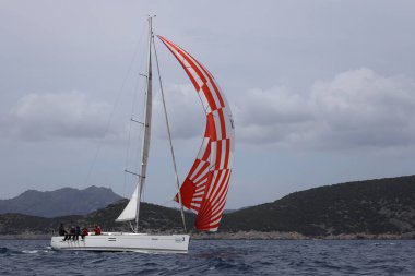 Bodrum, Hindi. 01 Nisan 2023: Ege Denizi 'nin mavi sularında, ünlü tatil beldesi Bodrum' un kıyılarında, rüzgarlı havada yelkenliler yelken açıyor.