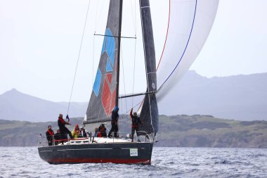 Bodrum, Hindi. 01 Nisan 2023: Ege Denizi 'nin mavi sularında, ünlü tatil beldesi Bodrum' un kıyılarında, rüzgarlı havada yelkenliler yelken açıyor.