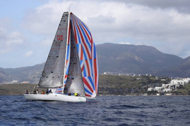 Bodrum, Hindi. 01 Nisan 2023: Ege Denizi 'nin mavi sularında, ünlü tatil beldesi Bodrum' un kıyılarında, rüzgarlı havada yelkenliler yelken açıyor.