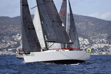 Bodrum, Hindi. 01 Nisan 2023: Ege Denizi 'nin mavi sularında, ünlü tatil beldesi Bodrum' un kıyılarında, rüzgarlı havada yelkenliler yelken açıyor.