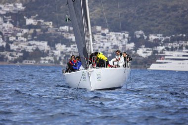 Bodrum, Hindi. 01 Nisan 2023: Ege Denizi 'nin mavi sularında, ünlü tatil beldesi Bodrum' un kıyılarında, rüzgarlı havada yelkenliler yelken açıyor.