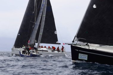 Bodrum, Hindi. 01 Nisan 2023: Ege Denizi 'nin mavi sularında, ünlü tatil beldesi Bodrum' un kıyılarında, rüzgarlı havada yelkenliler yelken açıyor.