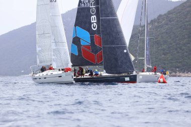 Bodrum, Hindi. 01 Nisan 2023: Ege Denizi 'nin mavi sularında, ünlü tatil beldesi Bodrum' un kıyılarında, rüzgarlı havada yelkenliler yelken açıyor.