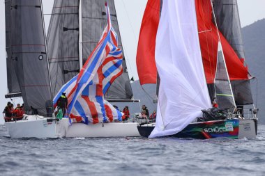 Bodrum, Hindi. 01 Nisan 2023: Ege Denizi 'nin mavi sularında, ünlü tatil beldesi Bodrum' un kıyılarında, rüzgarlı havada yelkenliler yelken açıyor.