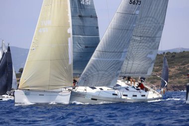 Bodrum, Hindi. 07 Mayıs 2023: Ege Denizi 'nin mavi sularında, ünlü tatil beldesi Bodrum' un kıyılarında yelkenliler rüzgarlı havada yelken açıyor.