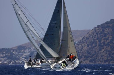 Bodrum, Hindi. 07 Mayıs 2023: Ege Denizi 'nin mavi sularında, ünlü tatil beldesi Bodrum' un kıyılarında yelkenliler rüzgarlı havada yelken açıyor.