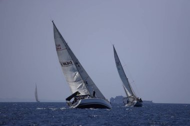 Bodrum, Hindi. 07 Mayıs 2023: Ege Denizi 'nin mavi sularında, ünlü tatil beldesi Bodrum' un kıyılarında yelkenliler rüzgarlı havada yelken açıyor.