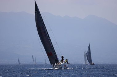 Bodrum, Hindi. 07 Mayıs 2023: Ege Denizi 'nin mavi sularında, ünlü tatil beldesi Bodrum' un kıyılarında yelkenliler rüzgarlı havada yelken açıyor.