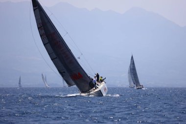 Bodrum, Hindi. 07 Mayıs 2023: Ege Denizi 'nin mavi sularında, ünlü tatil beldesi Bodrum' un kıyılarında yelkenliler rüzgarlı havada yelken açıyor.