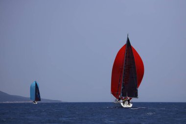 Bodrum, Hindi. 07 Mayıs 2023: Ege Denizi 'nin mavi sularında, ünlü tatil beldesi Bodrum' un kıyılarında yelkenliler rüzgarlı havada yelken açıyor.