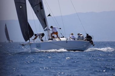 Bodrum, Hindi. 07 Mayıs 2023: Ege Denizi 'nin mavi sularında, ünlü tatil beldesi Bodrum' un kıyılarında yelkenliler rüzgarlı havada yelken açıyor.