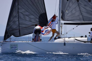 Bodrum, Hindi. 07 Mayıs 2023: Ege Denizi 'nin mavi sularında, ünlü tatil beldesi Bodrum' un kıyılarında yelkenliler rüzgarlı havada yelken açıyor.