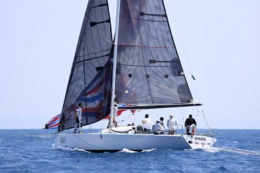Bodrum, Hindi. 07 Mayıs 2023: Ege Denizi 'nin mavi sularında, ünlü tatil beldesi Bodrum' un kıyılarında yelkenliler rüzgarlı havada yelken açıyor.