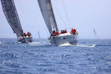 Bodrum, Hindi. 07 Mayıs 2023: Ege Denizi 'nin mavi sularında, ünlü tatil beldesi Bodrum' un kıyılarında yelkenliler rüzgarlı havada yelken açıyor.