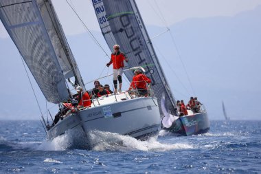 Bodrum, Hindi. 07 Mayıs 2023: Ege Denizi 'nin mavi sularında, ünlü tatil beldesi Bodrum' un kıyılarında yelkenliler rüzgarlı havada yelken açıyor.
