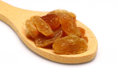 Tahta kaşıkta kahverengi kuru üzümler beyaz arka planda izole edilmiş ve kırpma yolu var. Üst Manzara. Düz yatıyordu