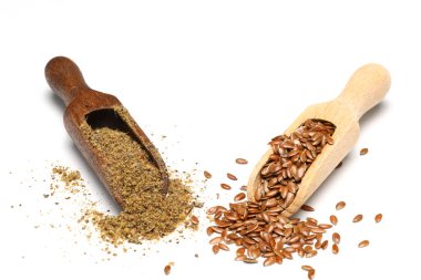 Keten tohumu. Tahta kaşıkta keten tohumu tozu. Beyaz bir arkaplanda duruyor.