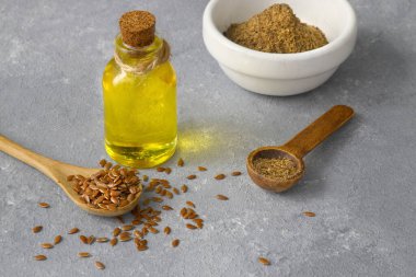 Keten tohumu. Tahta kaşıkta keten tohumu tozu. Tahta bir arka planda duruyor..