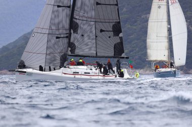 Bodrum, Hindi. 16 Nisan 2023: Yelkenliler Ege Denizi 'nin mavi sularında, ünlü tatil beldesi Bodrum' un kıyılarında rüzgarlı havada yelken açıyor..